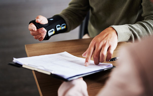 injured man hands pointing at insurance documents